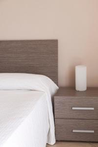 卡普多兰多Balconies d'Orlando的卧室配有白色的床和木制床头柜。