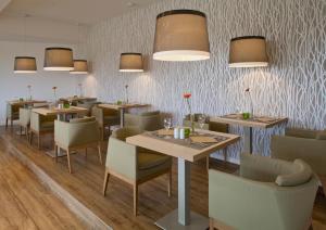 费曼城堡贝尼海滨酒店的用餐室配有桌椅和灯光