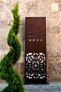 塞戈尔韦马丁胡马诺Spa酒店的砖墙上的一个标志,上面有圣诞树