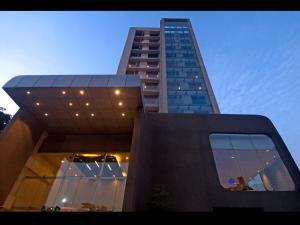 维沙卡帕特南Keys Select by Lemon Tree Hotels, Visakhapatnam的一座高大的建筑,前面设有玻璃窗