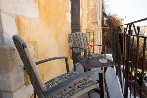 干尼亚波尔图之家酒店的阳台配有2把椅子和1张桌子