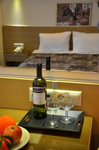科莫蒂尼凯瑞迪丝酒店的托盘上的一瓶葡萄酒和两杯酒