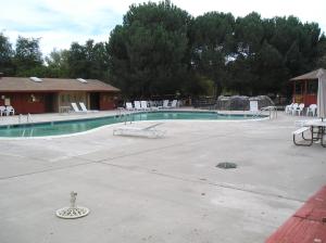 Paicines圣贝尼托露营11号度假屋 的一座带白色椅子和桌子的空游泳池