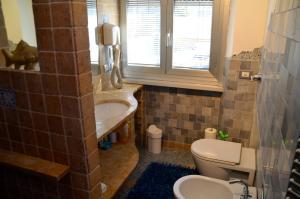 米兰复地之屋旅馆的一间带水槽和卫生间的浴室以及窗户。