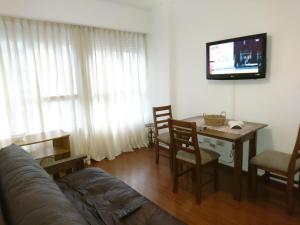 布宜诺斯艾利斯Apartamento Avenida de Mayo 1316的客厅配有桌子和墙上的电视