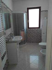 卡萨马西马L'Angolo di Pietra的浴室设有2个卫生间、水槽和淋浴。