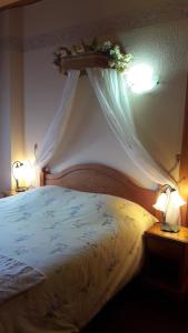 热拉梅爱皮纳特住宿加早餐旅馆的一间卧室配有一张带天蓬和两盏灯的床。