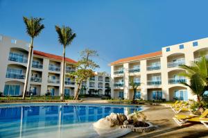 圣斐利-银港Cofresi Palm Beach & Spa Resort - All Inclusive的一个带游泳池和棕榈树的度假村