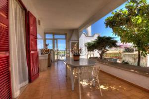 滨海波利尼亚诺Villa Portalga al mare的阳台的用餐室配有桌椅