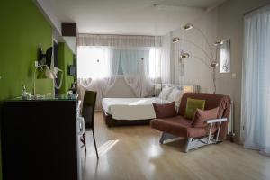 雅典雅典海比泰特酒店的一间卧室配有一张床、一把椅子、一张床和窗户。