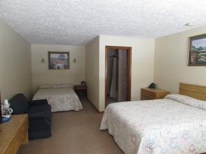 格雷灵Woodland Motor Lodge的酒店客房,配有两张床和椅子
