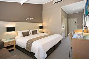 塔姆沃思贝斯维斯特圣域旅馆的酒店客房设有一张大床和一张书桌。