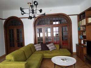 雅典科隆纳基装饰公寓的客厅配有绿色沙发和吊灯。