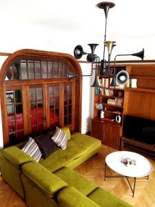 雅典科隆纳基装饰公寓的客厅配有绿色沙发和电视