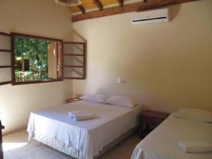 博尼图韦德别墅生态旅馆的一间卧室设有两张床和窗户。