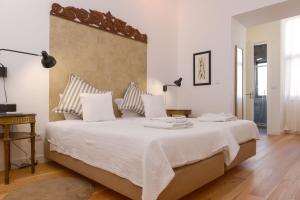 里斯本古尔本基安公寓的卧室配有一张带白色床单和枕头的大床。