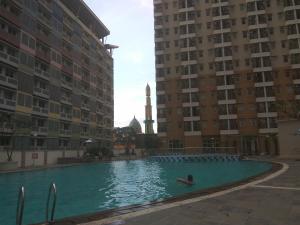 德波DSR马尔贡达2号公寓的两座建筑物之间的游泳池里的人