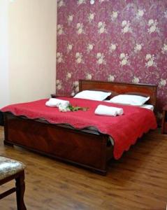 塔什干克拉特酒店的一间卧室配有红色床单和白色枕头。