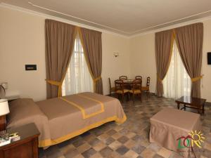 那不勒斯迪莫拉比迪鲁沃住宿加早餐旅馆的酒店客房配有一张床铺和一张桌子。