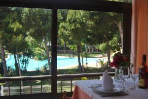 阿尔考斯布里桑丘三号酒店的一张桌子,透过窗户可欣赏到游泳池的景色