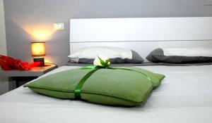 卢卡鸢尾花住宿加早餐旅馆的一张白色的床,上面有绿色枕头