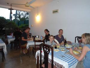 阿努拉德普勒小天堂旅游宾馆度假屋的一群坐在餐厅桌子上的人