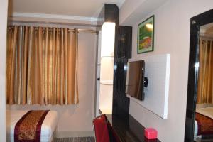 邦加槟港Puncak Budget Hotel的小房间设有床铺和电视