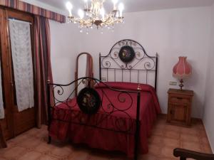 ChiblucoCasa Rural Benede的一间卧室配有一张带红毯和吊灯的床。