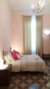 热那亚皇家套房旅馆的一间卧室配有一张带红色枕头的床和吊灯。