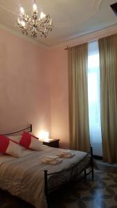 热那亚皇家套房旅馆的一间卧室配有一张带吊灯和窗户的床。