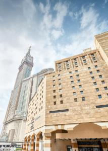 麦加马卡里姆爱迦德麦加酒店的一座高大的建筑,后面有钟楼