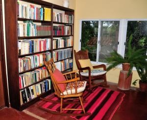 ChicoanaFinca Cielo Verde的图书馆配有两把椅子和书架,书架上摆放着书籍