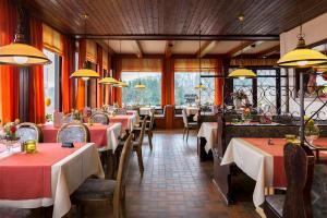 贝格施特拉瑟黑彭海姆瓦尔德肖克福尔酒店的餐厅配有桌椅和红色桌布
