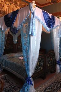 ArenaB&B Domenico Cesarelli的一间卧室配有天蓬床和蓝白色窗帘
