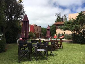 格塞尔镇Villa Olimpia Cabañas的院子里的桌椅和遮阳伞