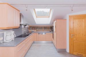 莱奥冈Stockingbauer的厨房配有木制橱柜和窗户。