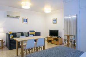 米尔芳提斯城杜纳马尔公寓的客厅配有桌椅和电视。