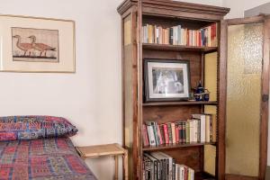 帕尔马Studio Borgo Colonne的一间卧室,书架上摆放着书籍