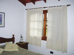 圣克莱门特雷图尤Cabañas El Maiten的一间卧室配有床和带窗帘的窗户
