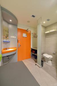 日惹POP! 提莫赫日惹酒店的浴室设有橙色门、盥洗盆和卫生间。
