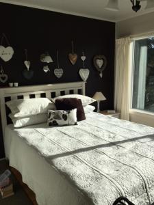 奥克兰海滨住宿加早餐旅馆的一间卧室设有一张大床和黑色墙壁