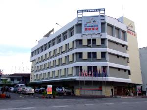 峇株巴辖京都酒店的一座白色的大建筑,上面有标志