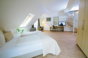 巴尔辛格豪森福克斯巴克塔尔运动酒店的白色的卧室设有一张大床和一个楼梯