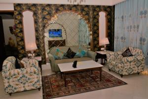 斋浦尔Indana Palace Jaipur的客厅配有两把椅子和一张桌子