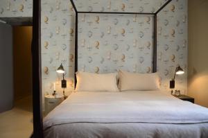 马泰拉圣尤斯塔其欧公寓的一间卧室配有一张带外壳壁的天蓬床。
