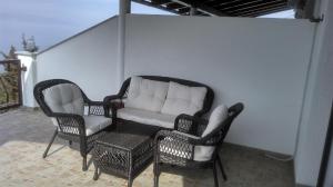 斯维蒂尤拉伊Delfin Apartments的天井上配有沙发和两把椅子