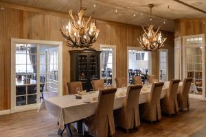 哈山Hafjell Hotell的大型用餐室配有长桌和吊灯