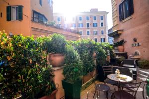 罗马费利斯酒店的大楼内的阳台配有桌子和盆栽植物