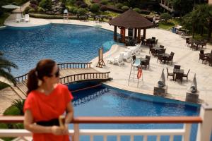 张家界张家界京武铂尔曼酒店（Ins红人首选）的站在游泳池附近的围栏上的女人