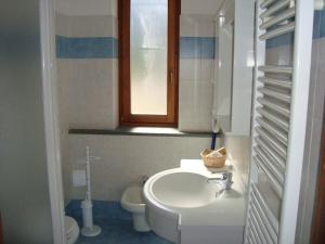 尚波吕克Affittacamere La Falconetta的一间带水槽和卫生间的浴室以及窗户。